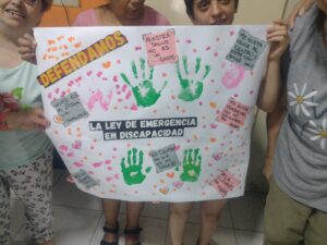 Concurrentes del Centro de Día "Wunjo", de la localidad de Remedios de Escalada, en la confección de carteles y consignas para reclamar por la plena implementación de la Ley de Emergencia en Discapacidad.